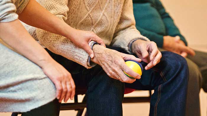 Woman holding hand of a elderly man