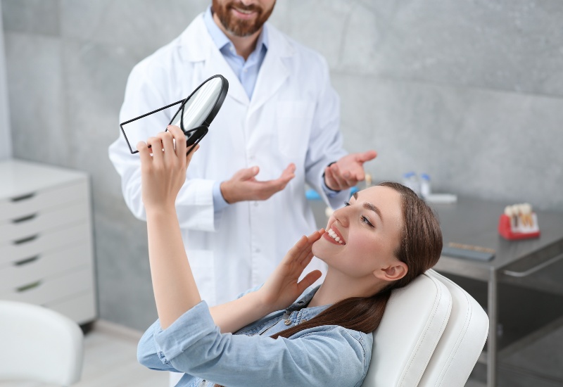 Patient checks teeth after crown treatment in Southfield, MI