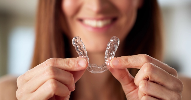 Person holding clear dental aligner in Southfield, MI