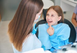 Dentist discussing teeth alignment options with young patient in Southfield, MI